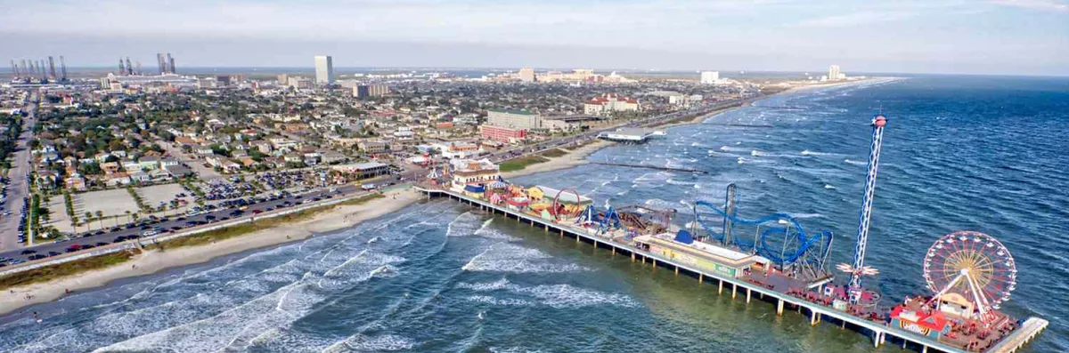 An aerial view of the Galveston Seawall and Pleasure Pier along the coastline