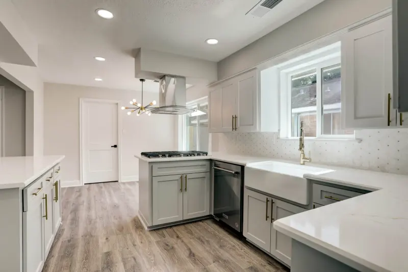 1622 Seagate Lane, Clear Lake: the renovated kitchen: gray shaker cabinets, white quartz counters and a farmhouse sink
